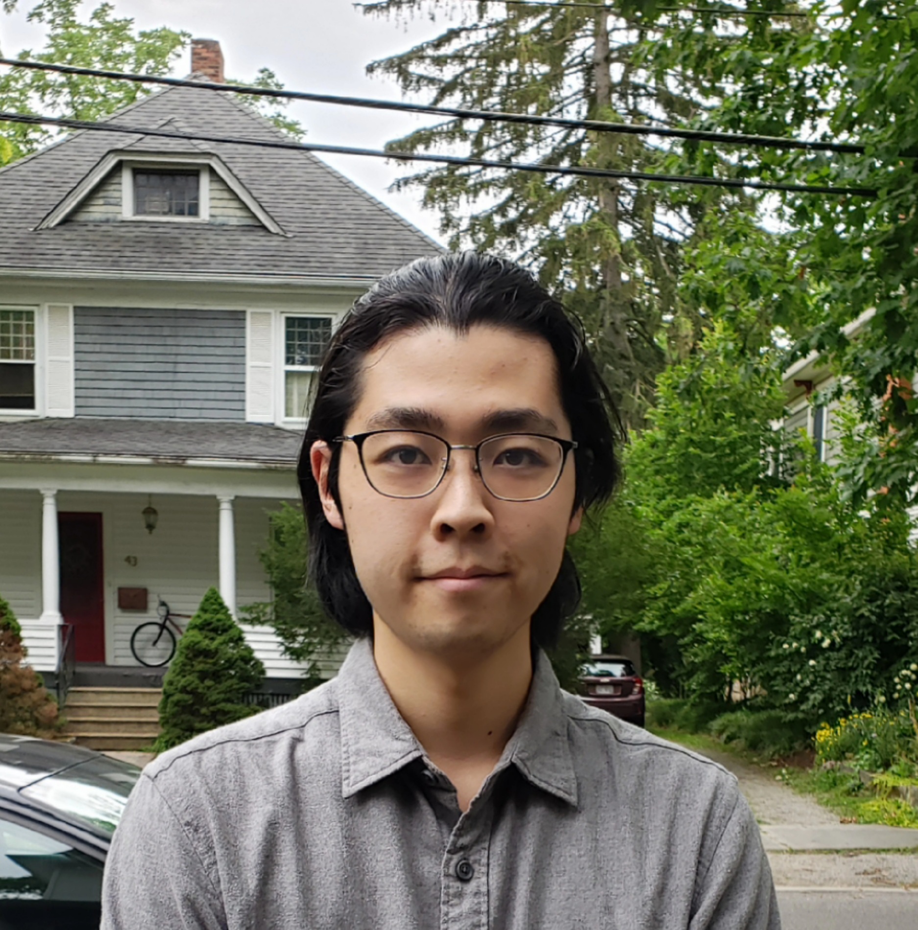 Person standing in front of a house with trees